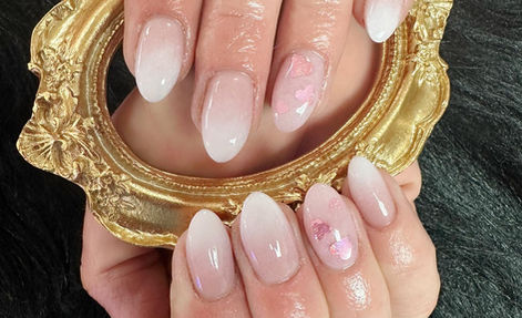 Glossy pink and white ombre nails with iridescent hearts
