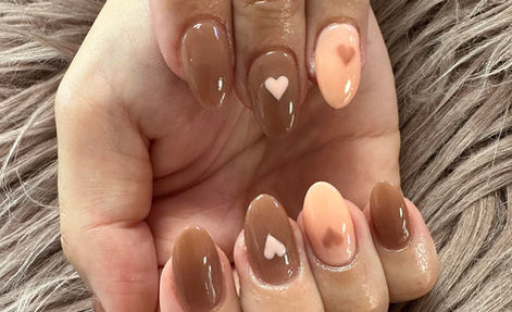 Glossy caramel and peach nails with heart accents