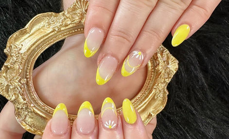 Bright yellow French-tip nails with white daisy details