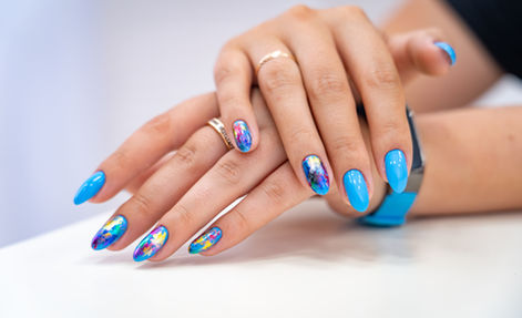 Bright blue manicure with multicoloured foil accents